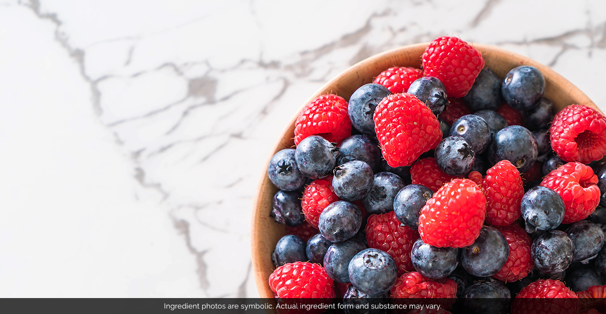 A wooden bowl full of raspberries and blueberries.